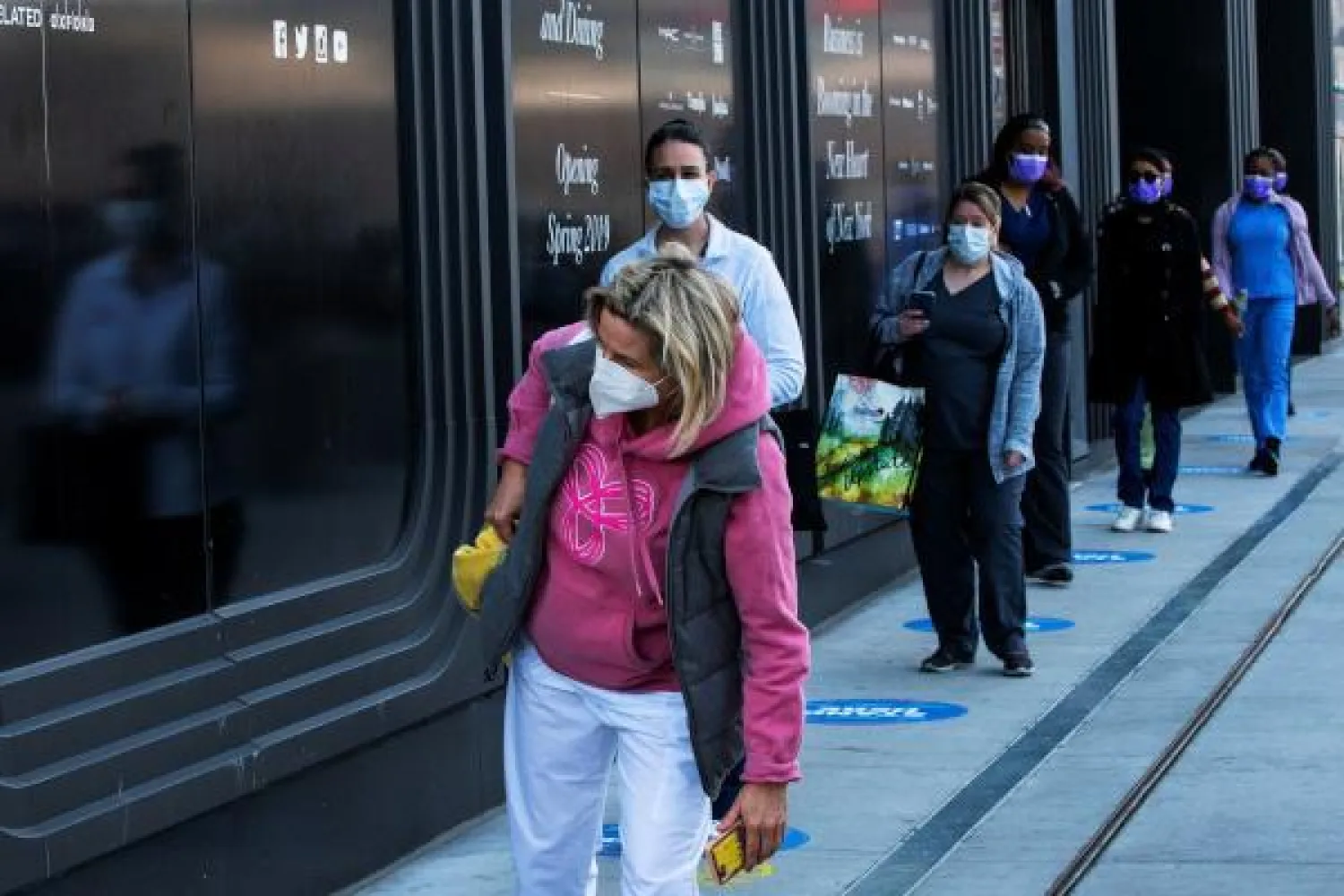 عاملون صحيون في طابور للحصول على الطعام في حي مانهاتن بمدينة نيويورك (رويترز)