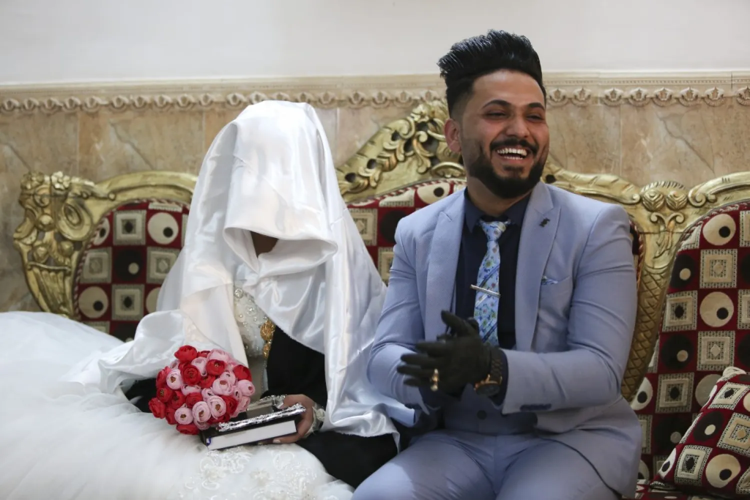 In this Thursday, April 9, 2020 photo, Ahmed Khaled al-Kaabi and his bride Ruqaya Rahim sit during their wedding in Najaf, Iraq, hardest hit town by coronavirus in the country with government banned large public gatherings. (AP Photo/Anmar Khalil)