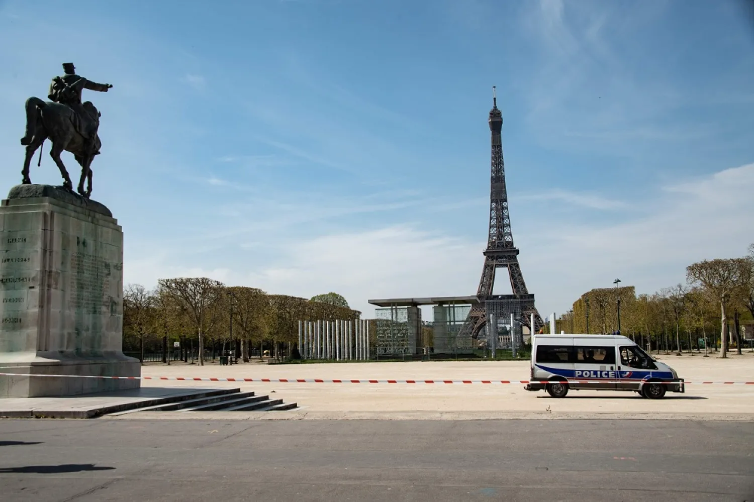A police van is parked in the closed Jardin du Champs de Mars garden in front of the Eiffel tower in Paris, France, Tuesday, April 7, 2020. (AFP)