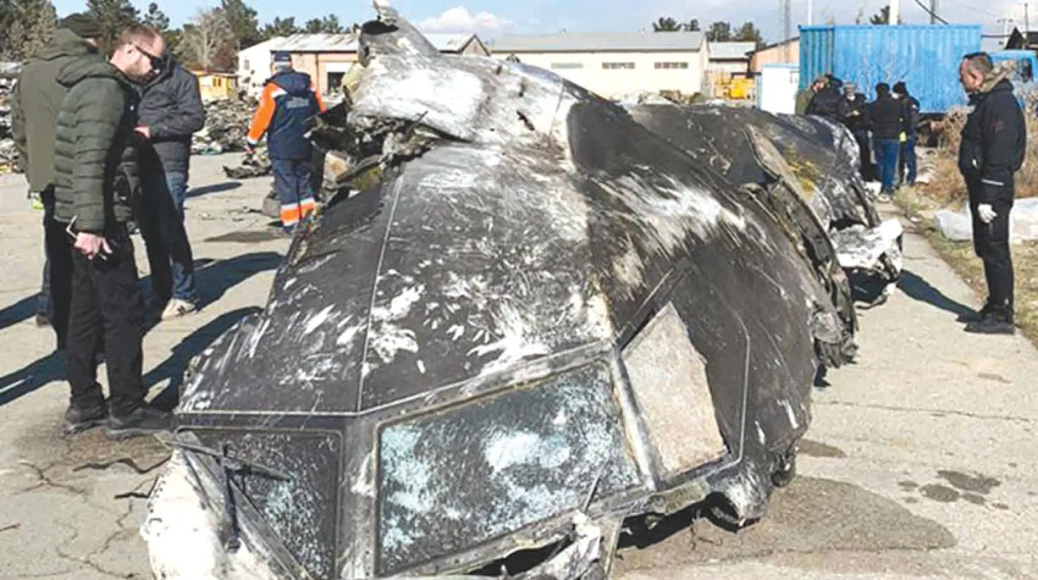 خبراء أوكرانيون أثناء التحقيق بموقع تحطم طائرة الركاب في منتصف يناير الماضي (أ.ف.ب)