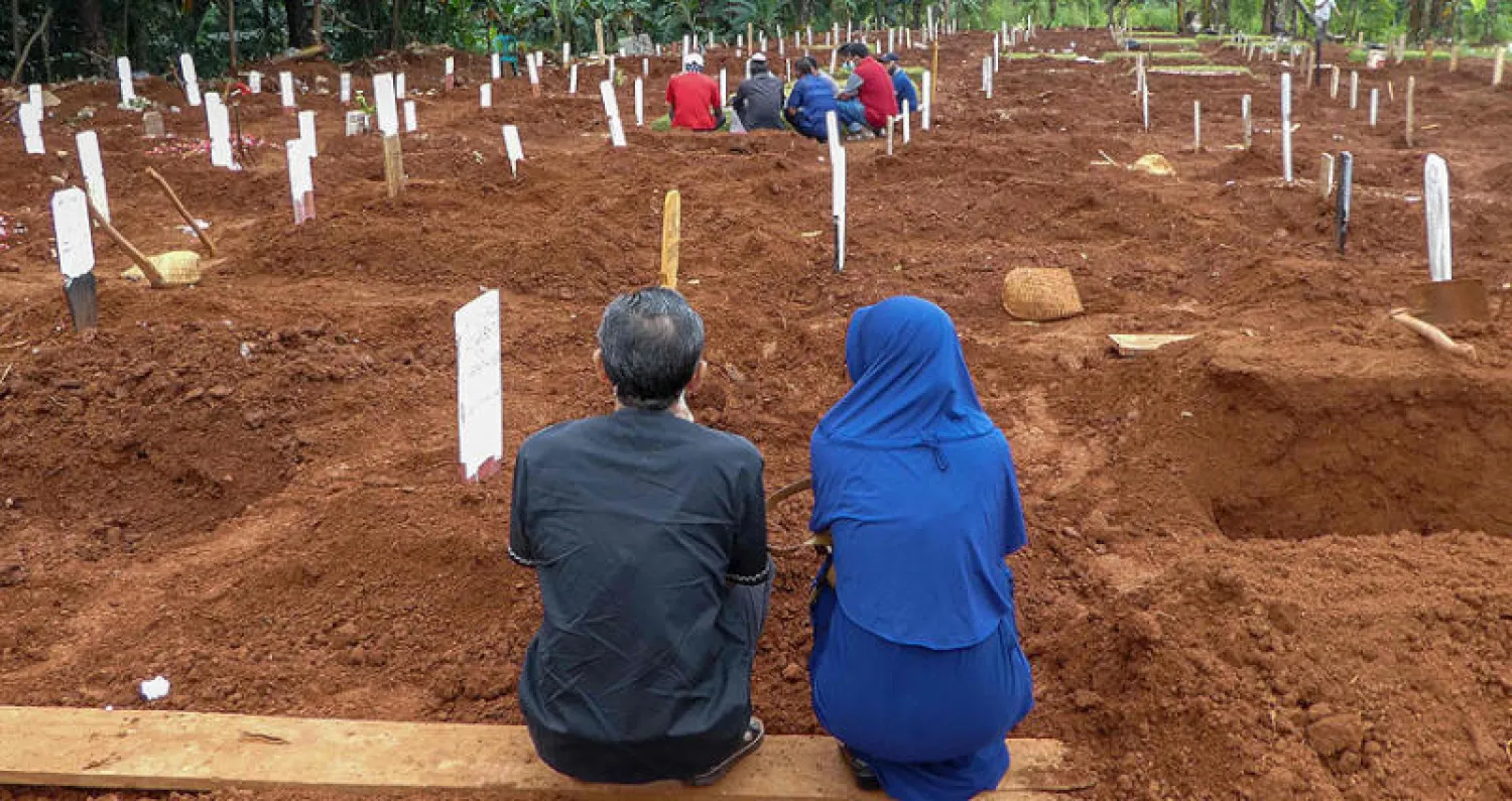 جانب من دفن أحد ضحايا «كورونا» في العاصمة الإندونيسية جاكرتا أمس (أ.ف.ب)