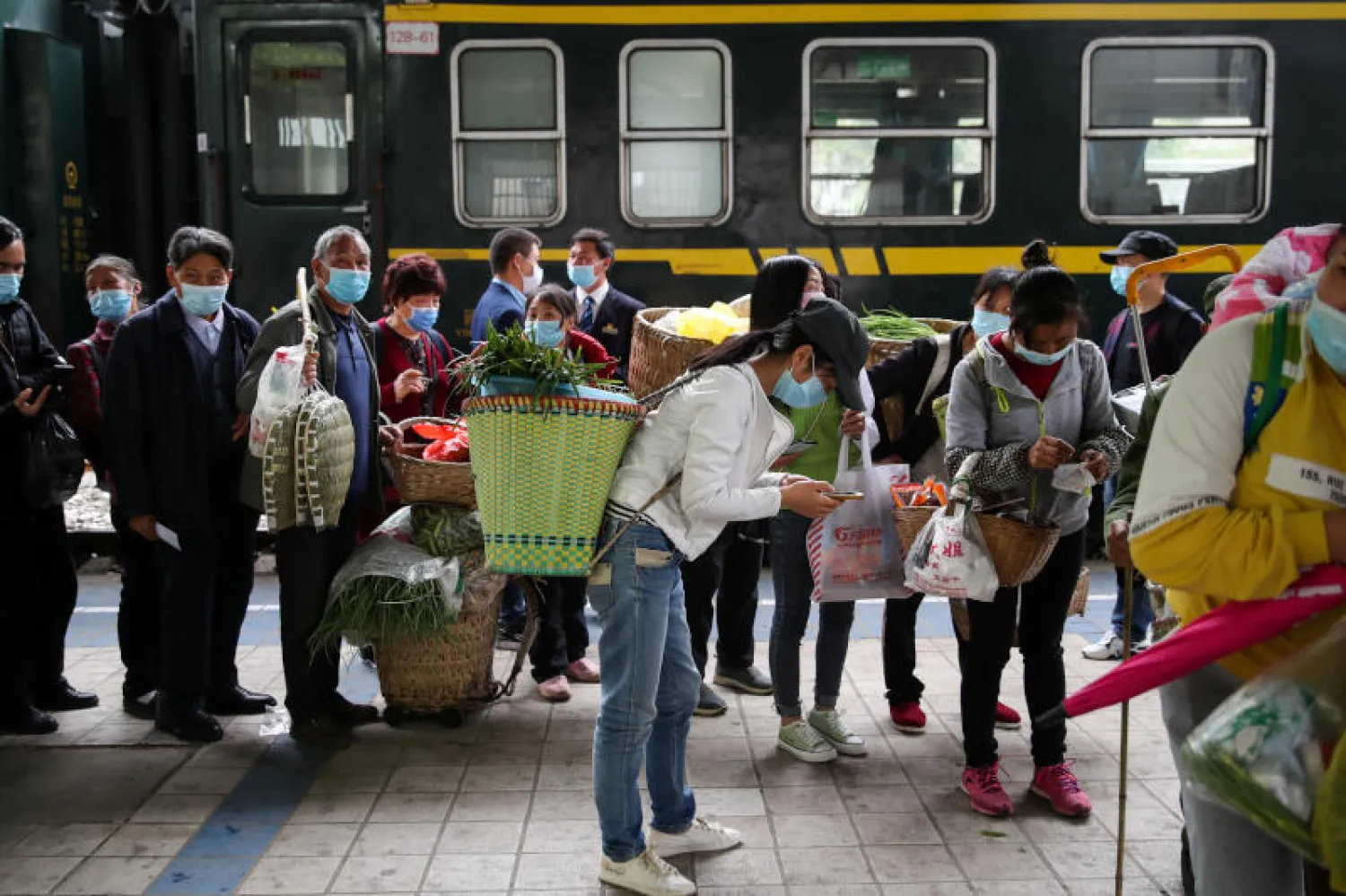 مسافرون بانتظار الفحص الطبي في الصين (رويترز)