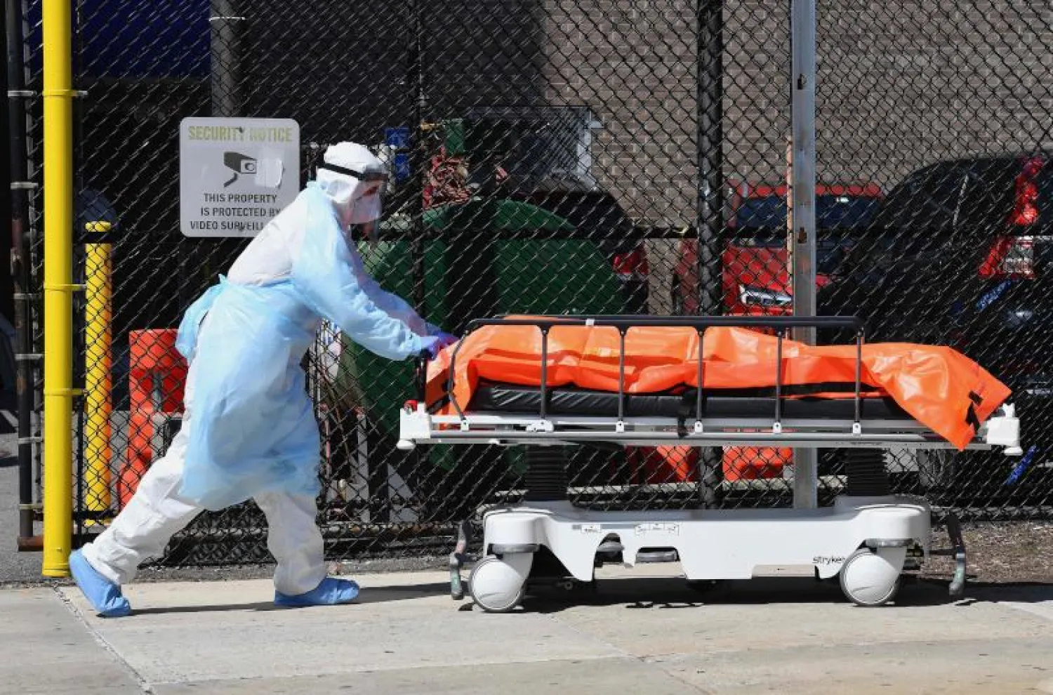 فرد من فريق طبي ينقل جثة إحدى ضحايا «كورونا» في نيويورك (أ.ف.ب)