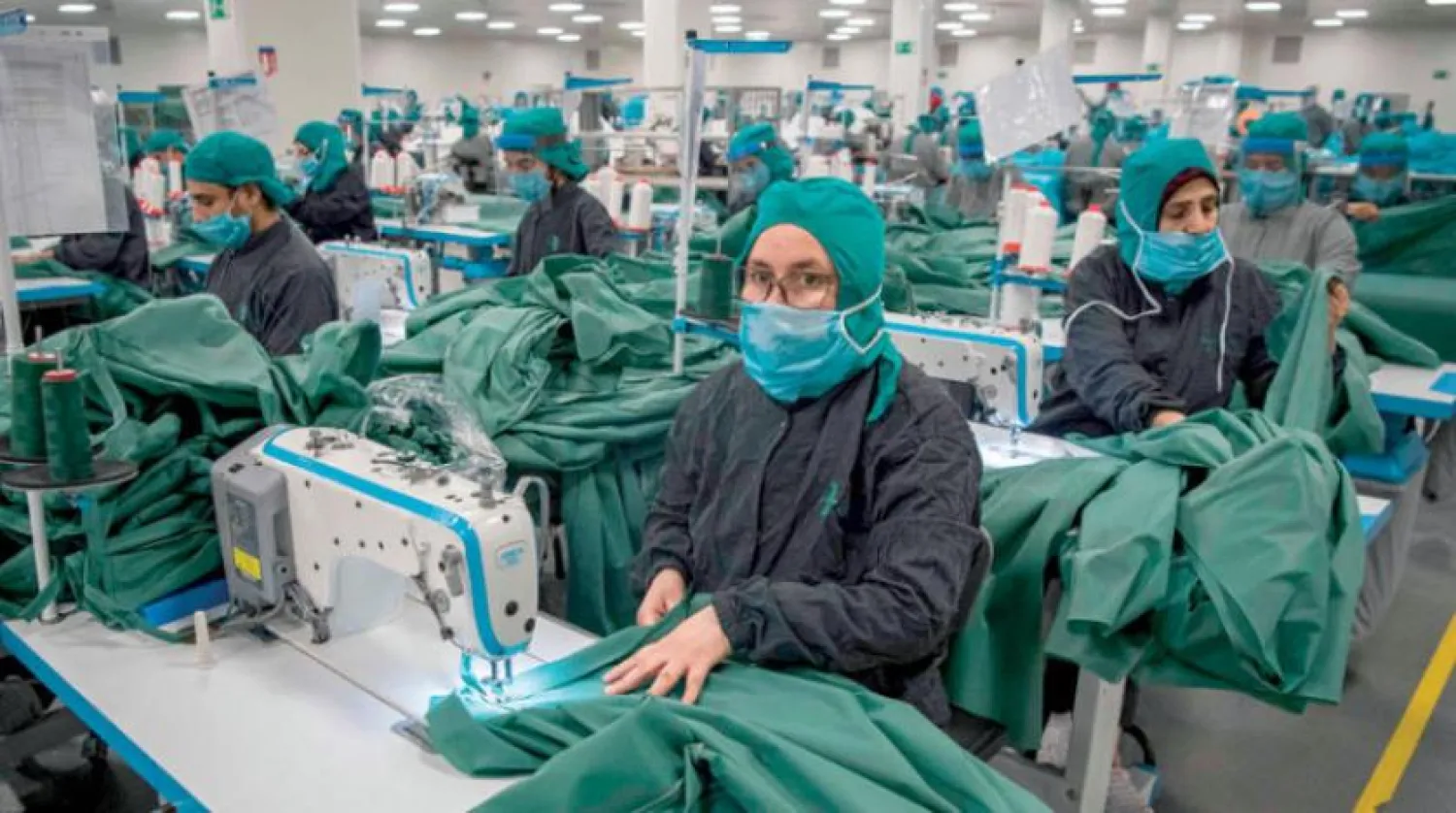 Kazablanka yakınlarındaki bir fabrikada sağlık çalışanlarını korumak için tıbbi yelek üreten işçiler. (AFP)