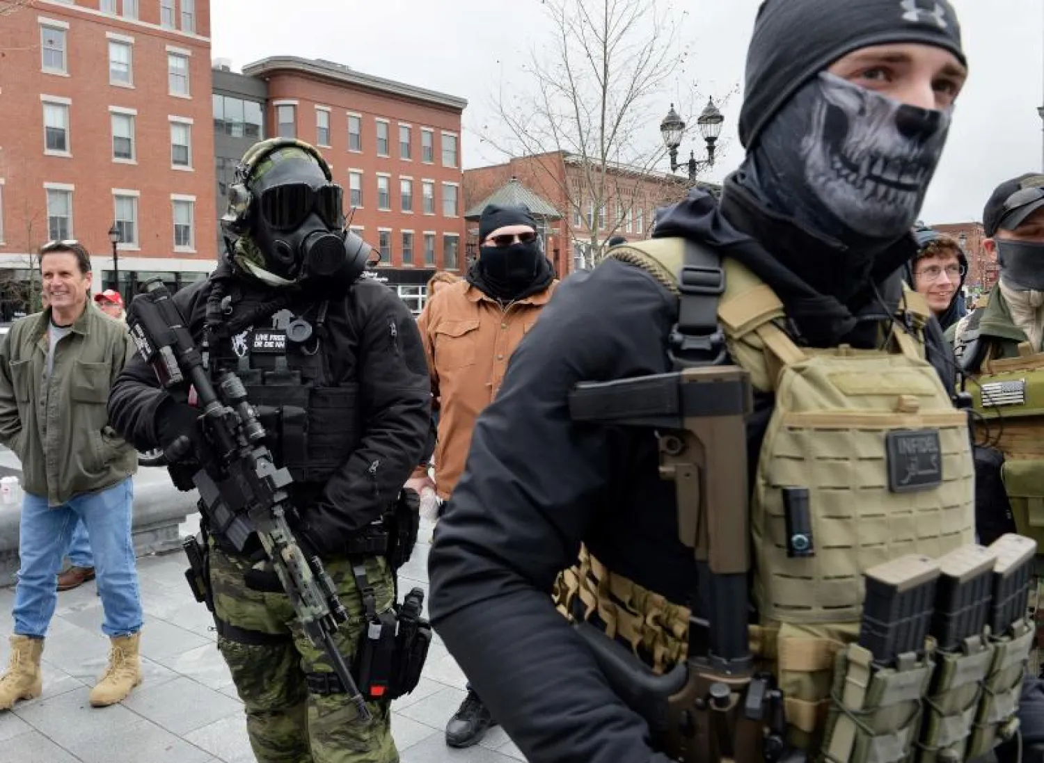 متظاهران مقنعان مسلحان أمام برلمان ولاية نيوهامشير الأميركية (أ.ف.ب)