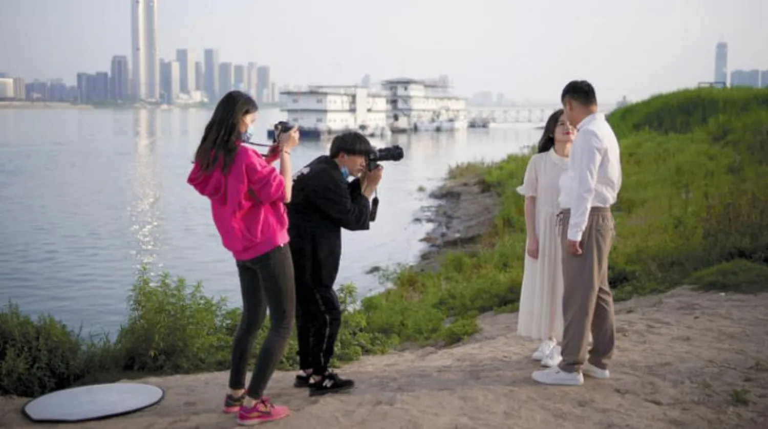 Salgının ortaya çıktığı Vuhan’da yetkililerin bazı önlemleri hafifletmesinin ardından Yangtze Nehri yanında yapılan düğün çekimi (Reuters)