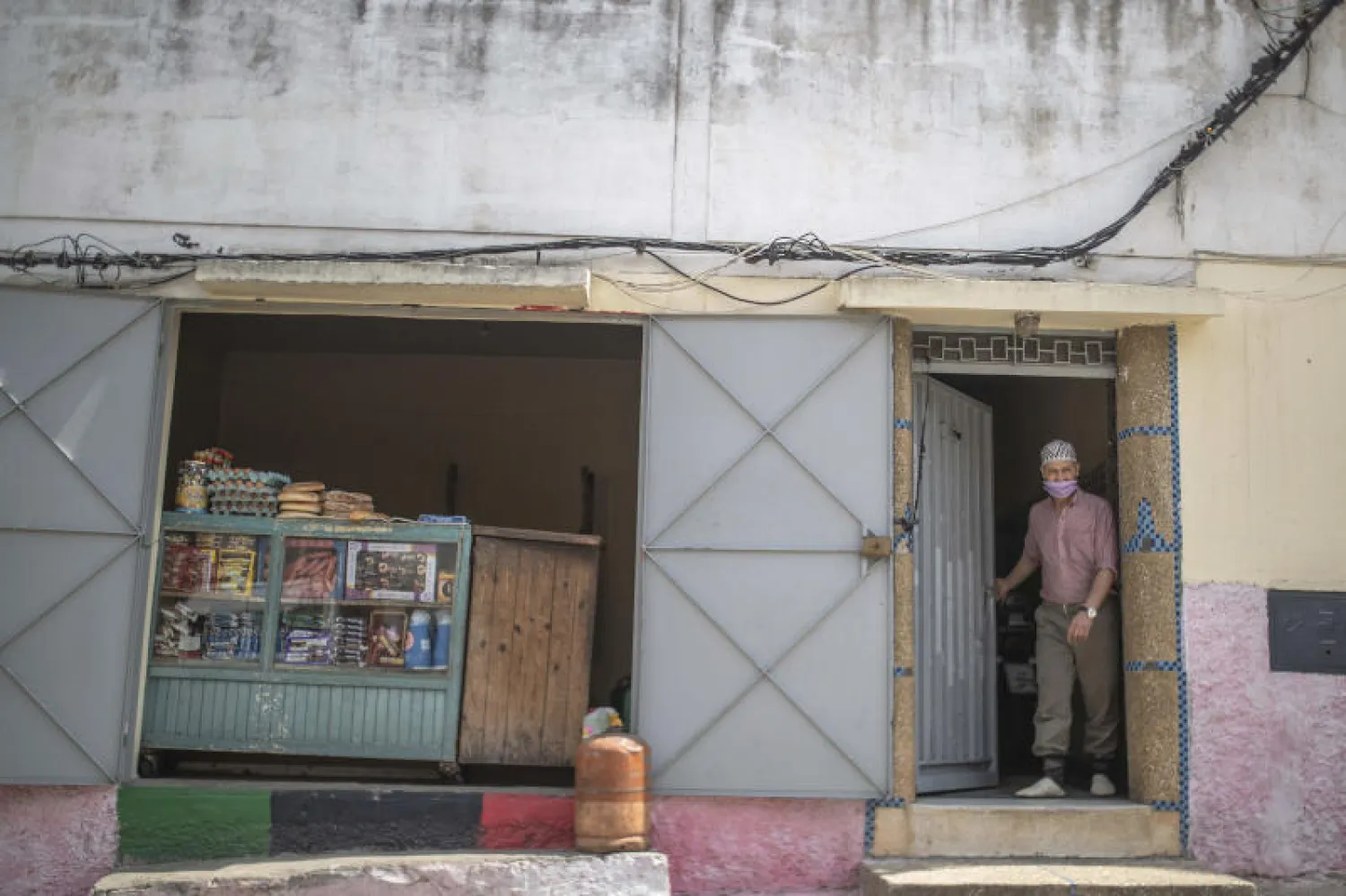صاحب متجر في الرباط بانتظار قدوم الزبائن خلال ساعات رفع الحظر (أ.ب)