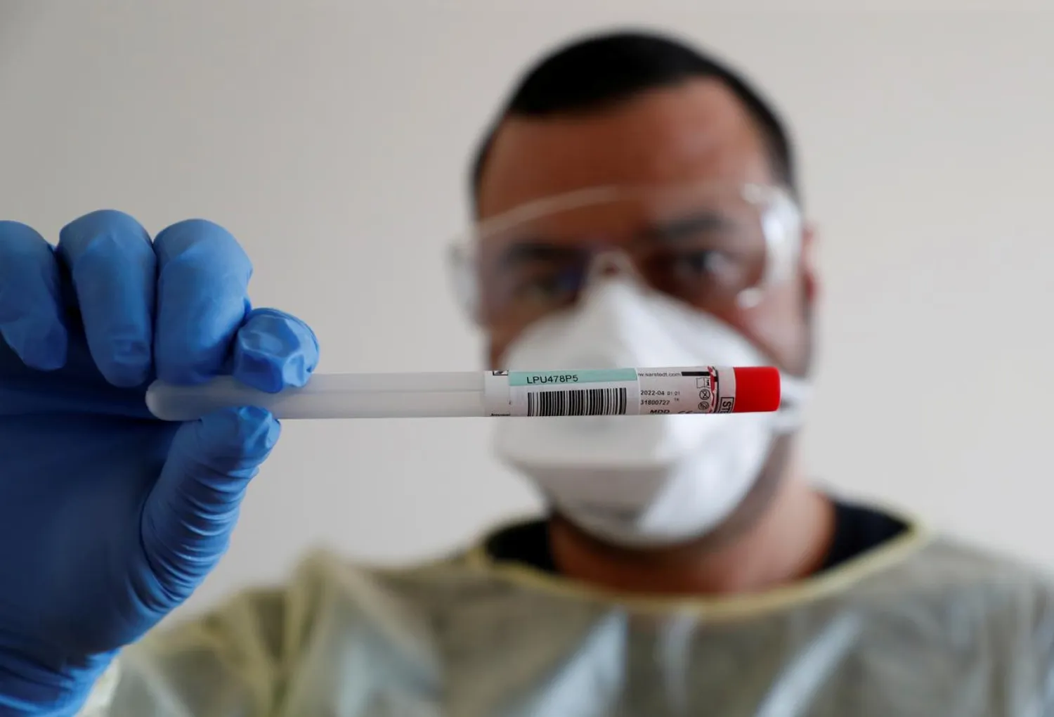 FILE PHOTO: A member of the medical staff shows a used sample container at a test centre for coronavirus disease (COVID-19) at Havelhoehe community hospital in Berlin, Germany, April 6, 2020. REUTERS/Fabrizio Bensch
