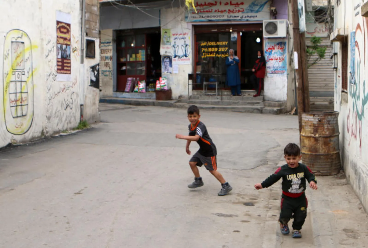 طفلان يلهوان في مخيم الجليل للاجئين الفلسطينيين في البقاع حيث اكتُشف عدد من الإصابات بفيروس «كورونا» (أ.ف.ب)