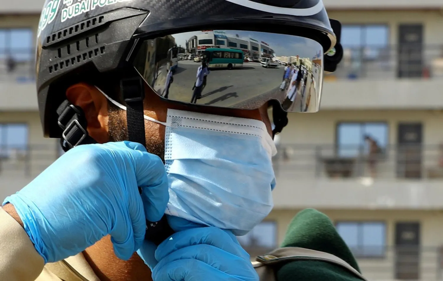 A police officer wears a smart helmet as he uses it to test the temperature of the workers during the outbreak of the coronavirus in Dubai, UAE, April 23, 2020. (Reuters)