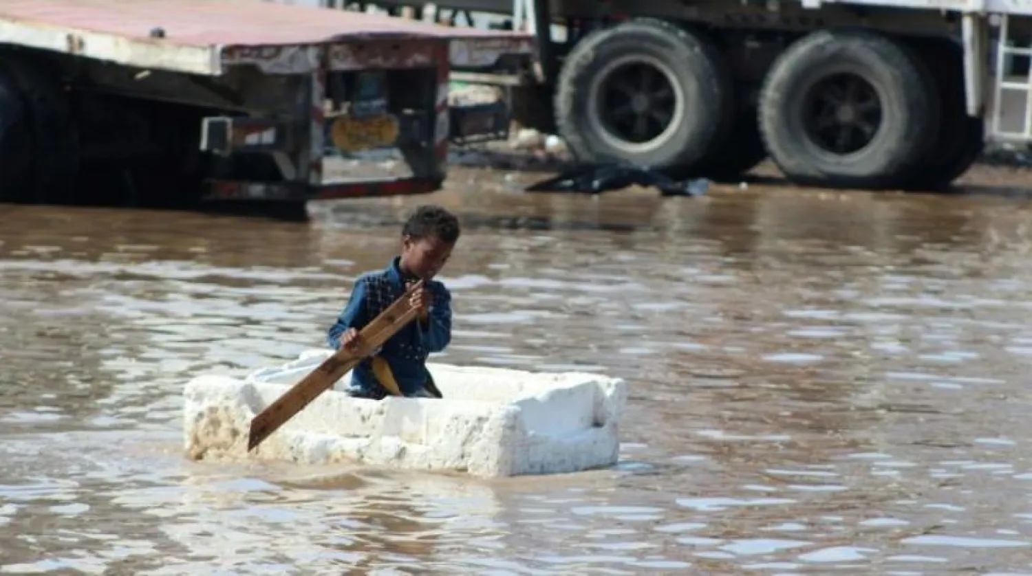 A Yemeni boy used a Styrofoam box and wooden plank to row across a flooded street in the southern city of Aden on April 22, 2020 (AFP Photo/Saleh Al-OBEIDI)
