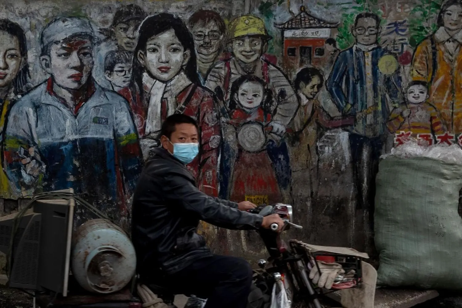 Wuhan’da motosiklete binen bir Çinli. (AFP)
