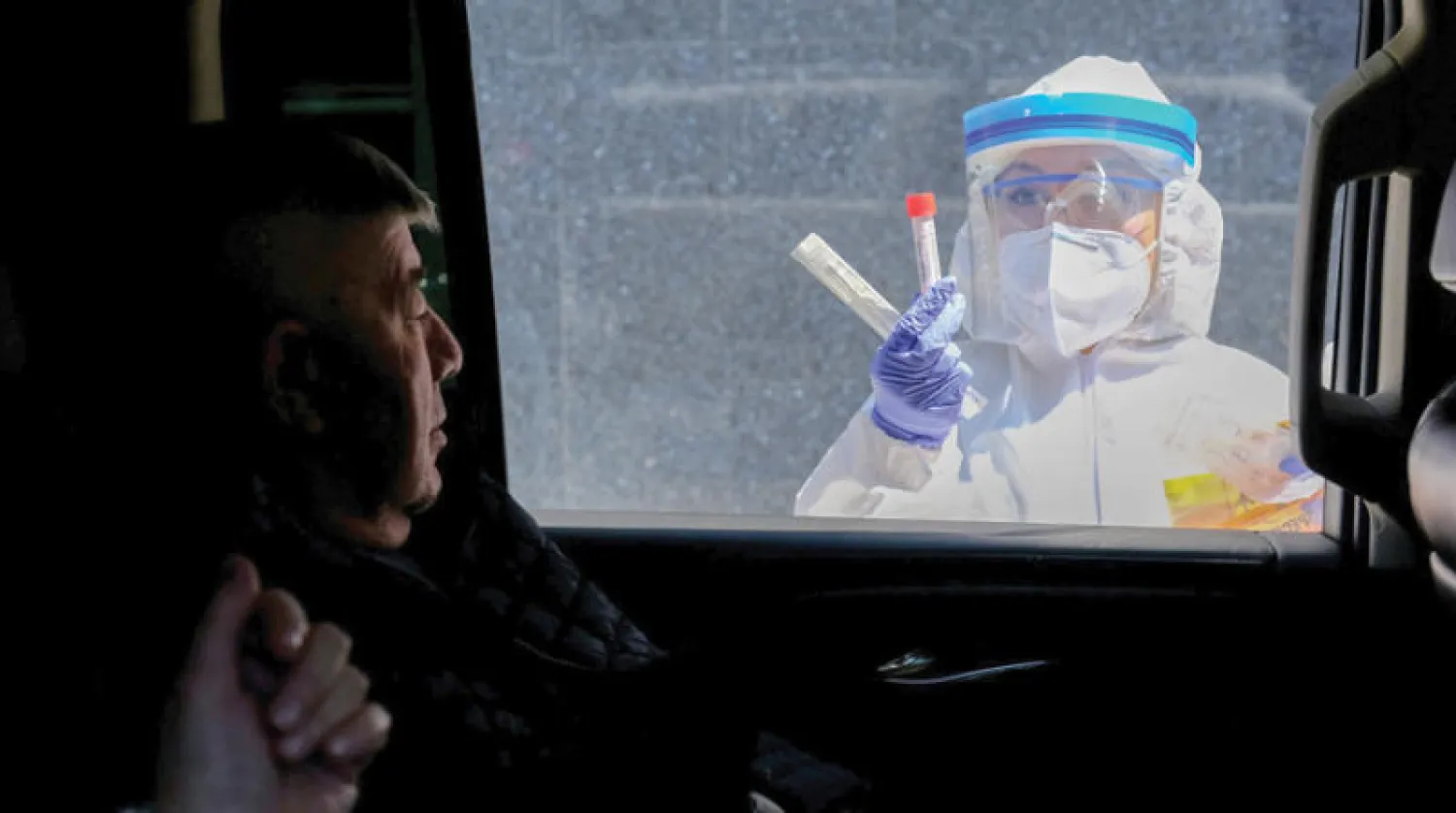 عاملة صحة تشرح لمصاب محتمل كيفية إجراء فحص {كورونا} في بروكلين (نيويورك تايمز)