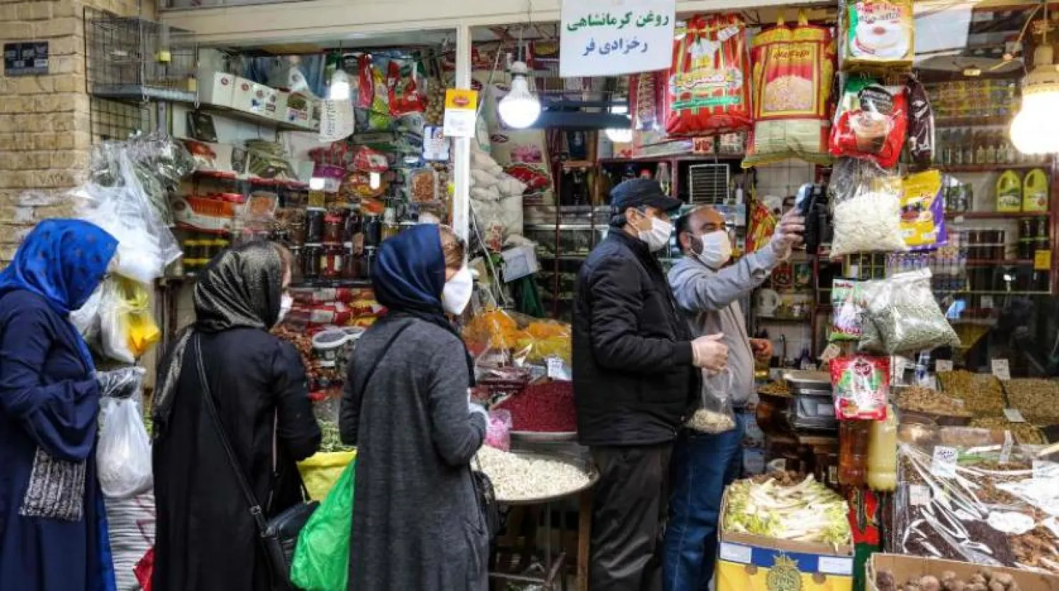 Tahran’da yüzlerinde maskeleriyle alışveriş yapan insanlar (AFP)
