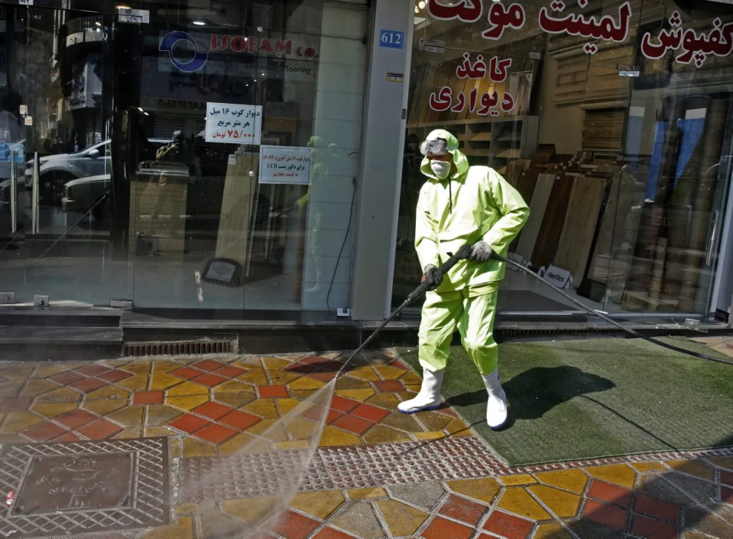 Iranian fire fighters and municipality workers disinfect a street in the capital Tehran for corona virus COVID-19 on March 5, 2020 (STR / AFP)
