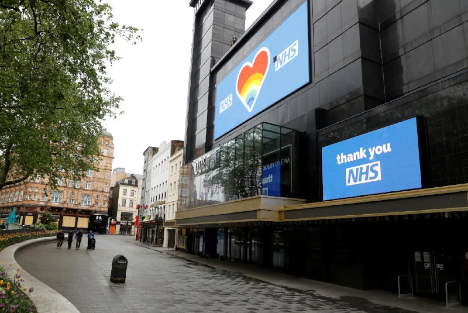 دار سينمائية مقفلة في ساحة ليستر سكوير بلندن تعرض لافتات داعمة لهيئة الخدمات الصحية الوطنية (رويترز)