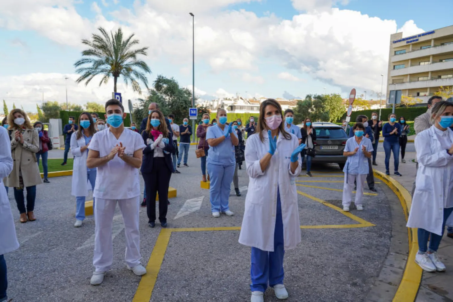 عاملون في الجهاز الطبي يوجهون تحية إلى روح طبيب توفي بفيروس «كورونا» في مدينة أشبيلية الإسبانية (د.ب.أ)