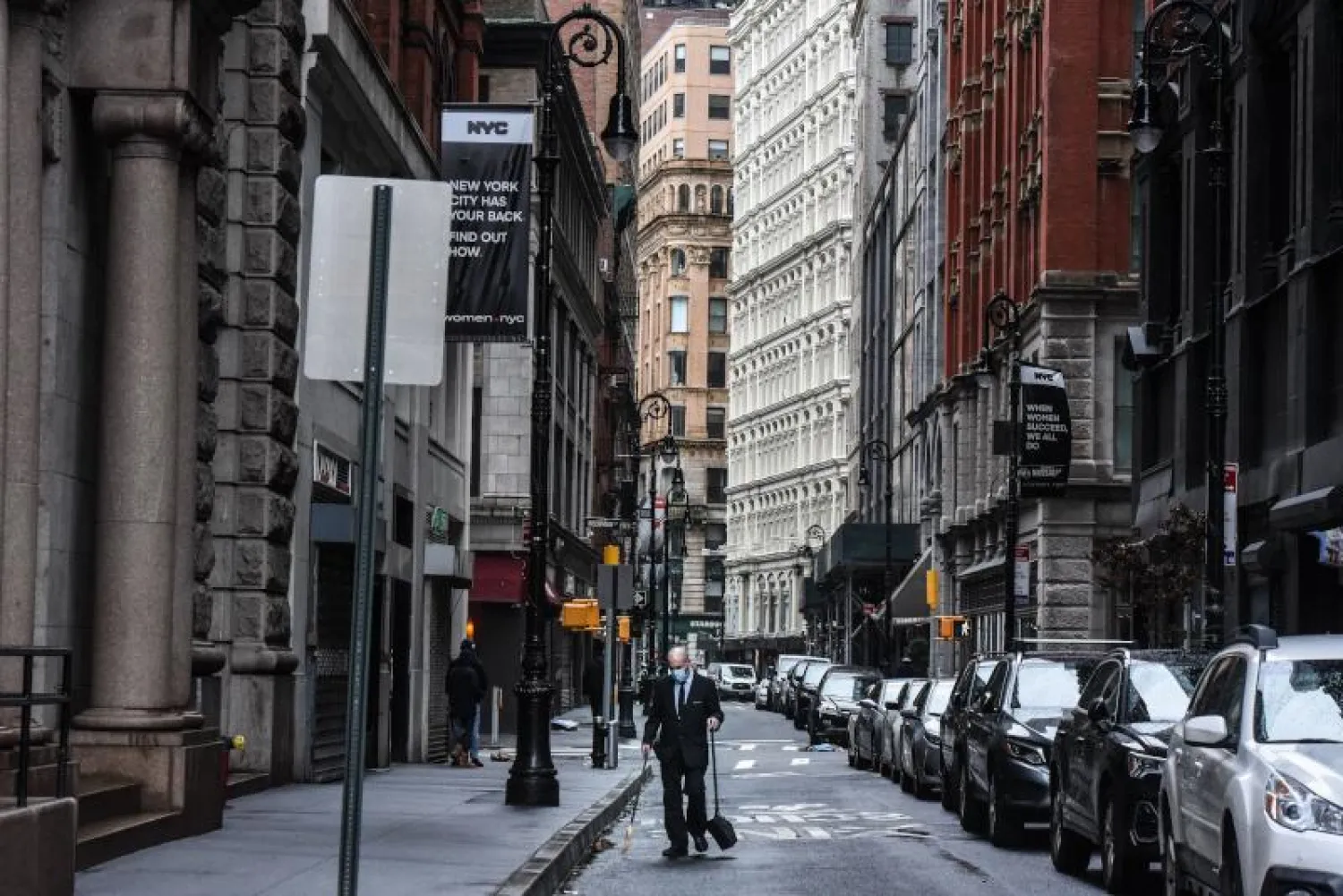 عامل في مبنى ينظف شارعاً شبه خالٍ في نيويورك (أ.ف.ب)