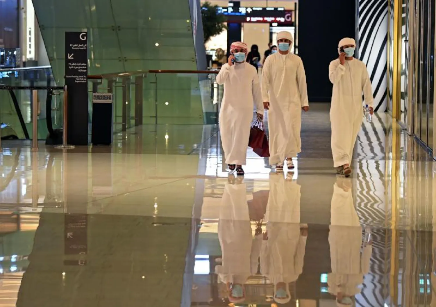 إماراتيون يرتدون أقنعة واقية لمكافحة فيروس كورونا (أ.ف.ب)