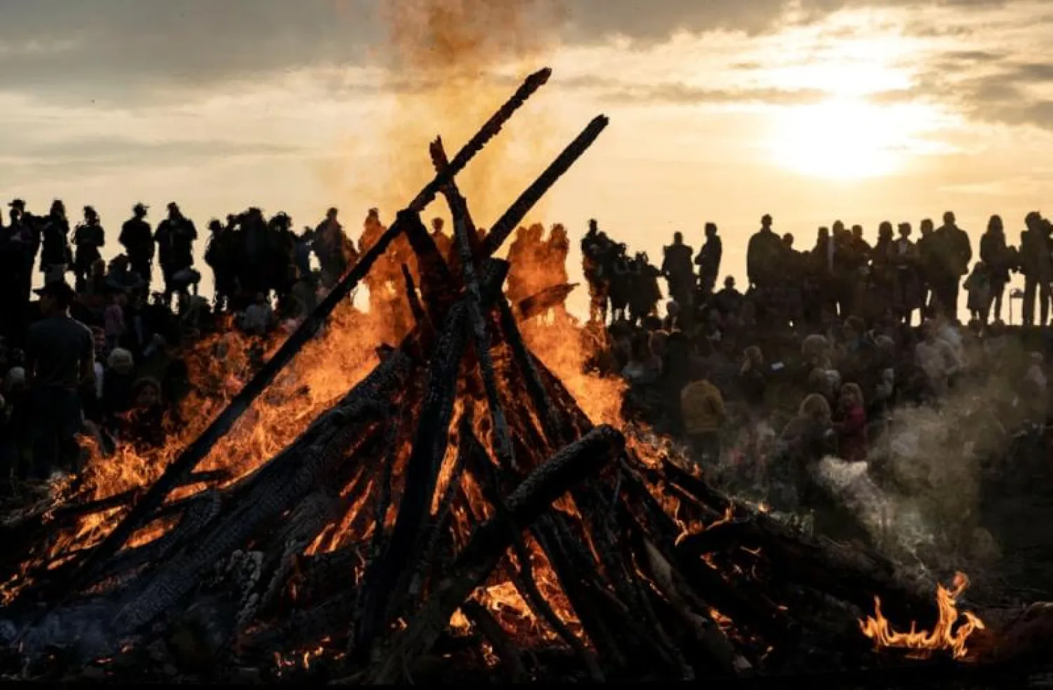 سويديون يتجمعون حول نيران مشتعلة بأحد المتنزهات احتفالاً بـ«ليلة فالبورغيس» (رويترز)