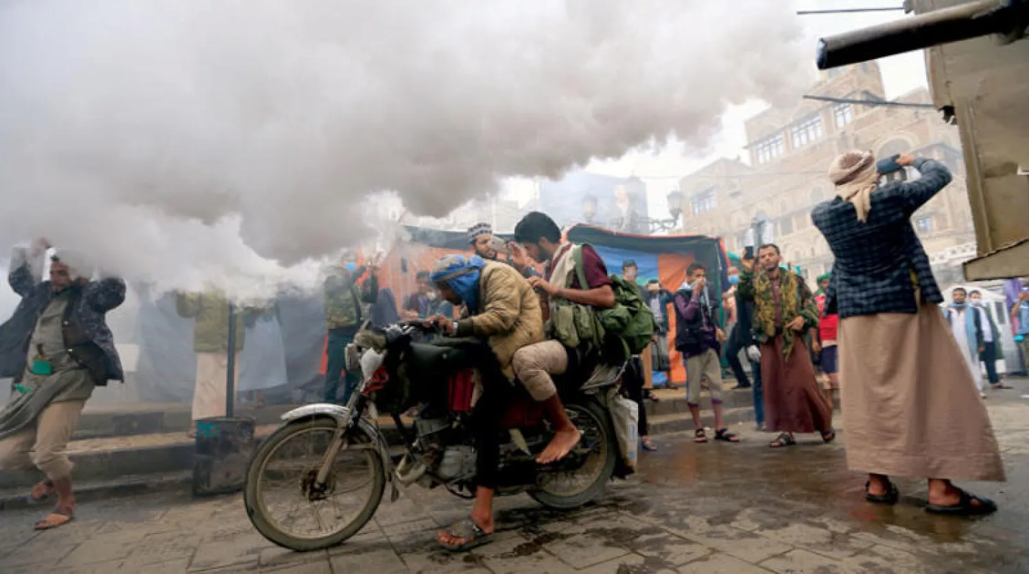 يمني يقود دراجته النارية وسط رذاذ التعقيم في صنعاء (أ.ف.ب)