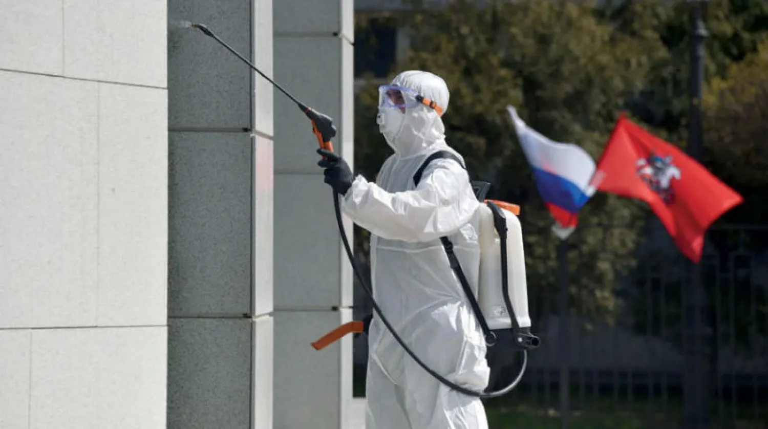 عامل يعقم مبنى حكومياً في موسكو أمس (أ.ف.ب)