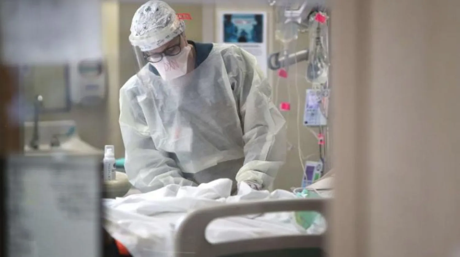 Bir hemşire, ABD'deki Maryland eyaletindeki bir hastanede bir koronavirüs hastasını tedavi yardımcı olur (AFP)