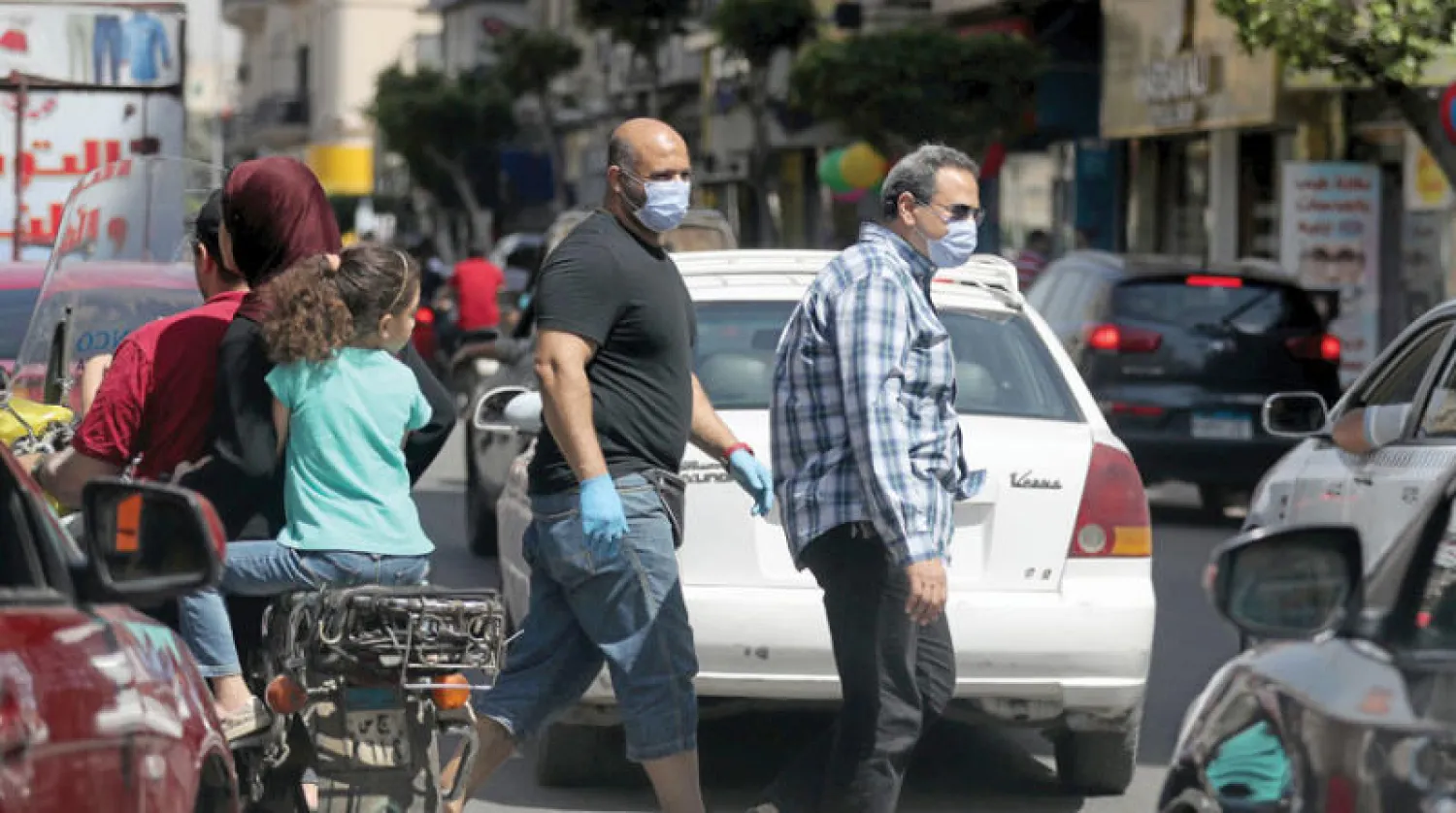 مصريون يضعون كمامات في القاهرة أمس (رويترز)