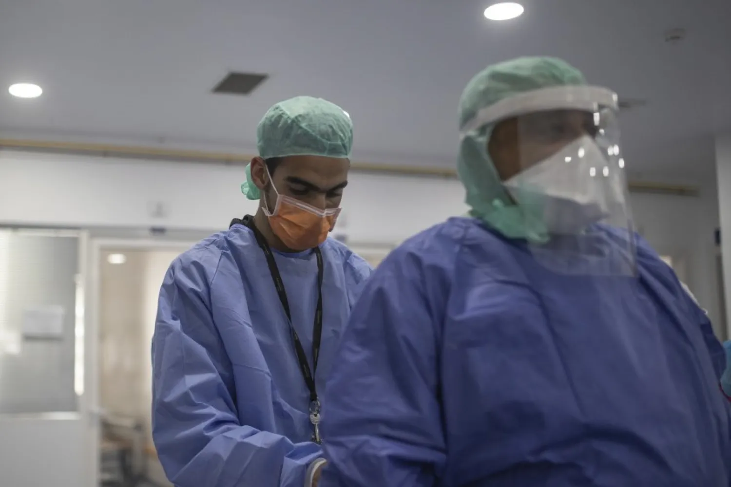 In this photo taken on Wednesday, April 15, 2020, healthcare workers assist each other inside one of the COVID-19 intensive care units (ICU) of the Moulay Abdellah hospital in Sale, Morocco. (AP Photo/Mosa'ab Elshamy)