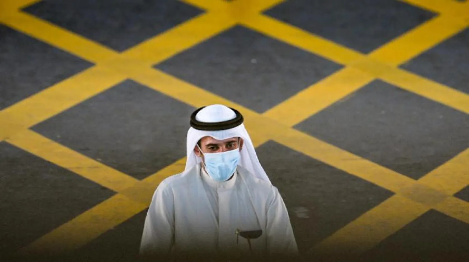 Kuveyt Uluslararası Havalimanı'nda koruyucu maske takan bir yolcu (EPA)