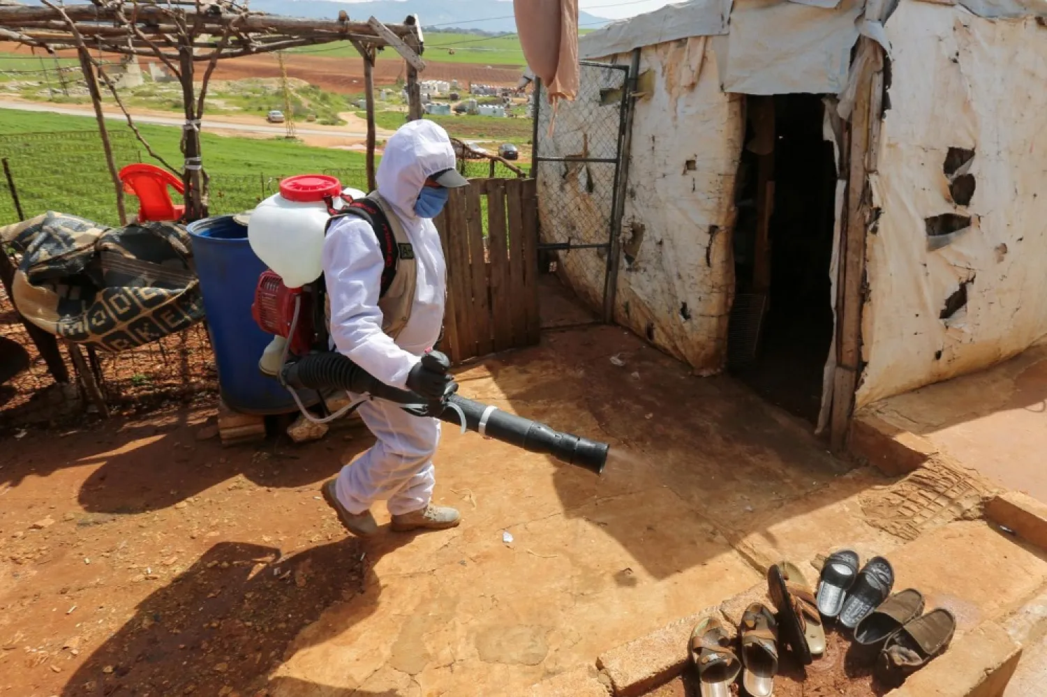 A worker disinfects a Syrian refugee camp in Lebanon on March 23, 2020. (Reuters)