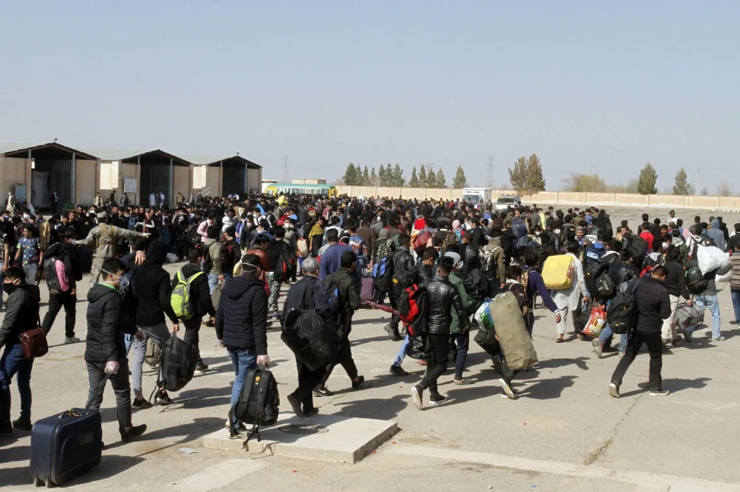 In this March 18, 2020 file photo, thousands of Afghan refugees walk as they enter Afghanistan at the Islam Qala border crossing with Iran, in the Herat province. (AP)