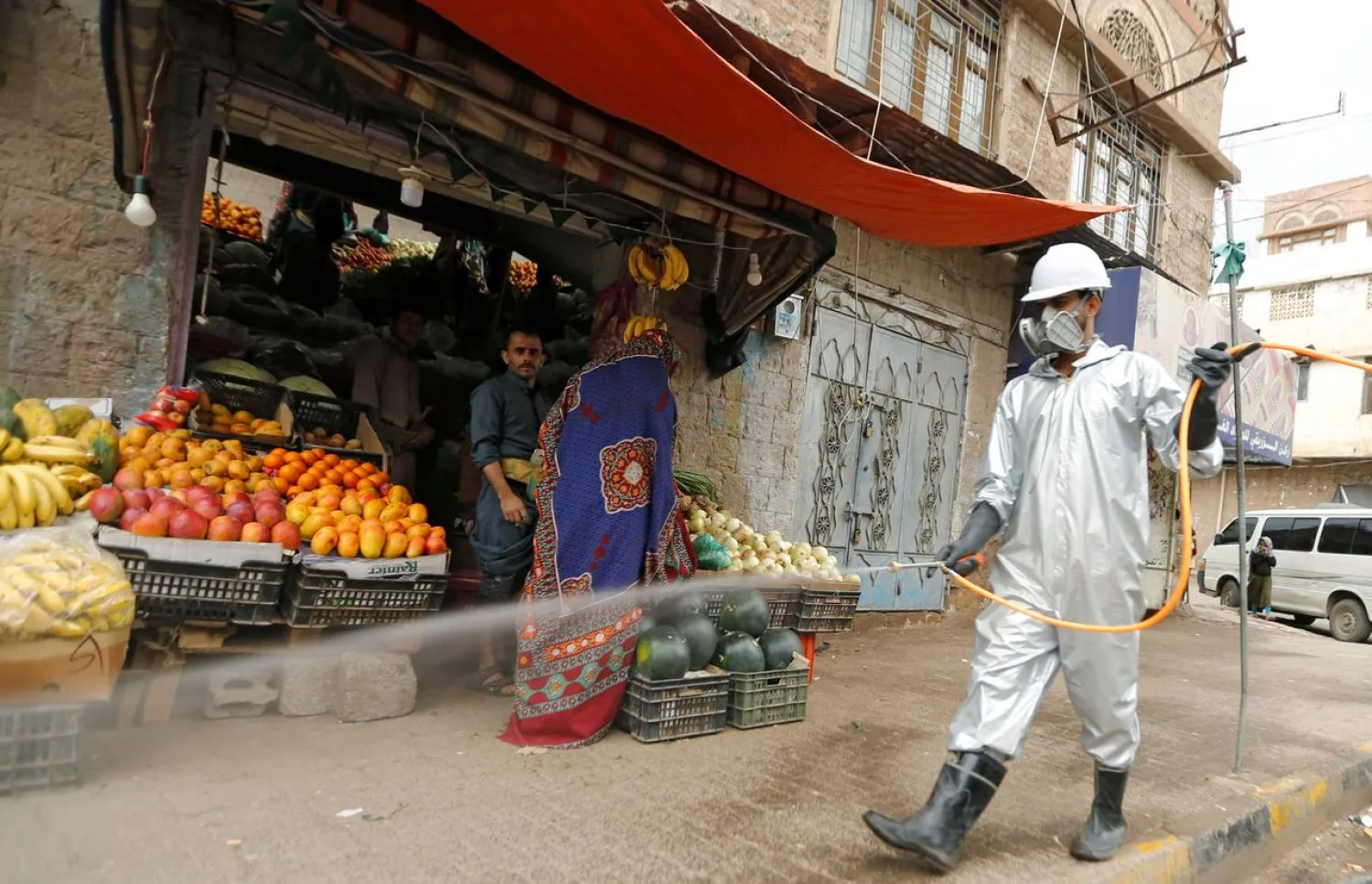 A health worker wearing a protective suit disinfects a market amid concerns of the spread of the coronavirus, in Sanaa, Yemen April 28, 2020. (Reuters)