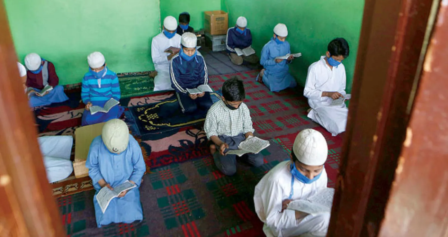 أطفال يقرأون القرآن الكريم في دار أيتام بسريناغار الأربعاء (إ.ب.أ)