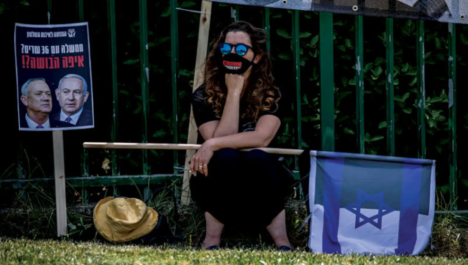 متظاهرة معترضة على الائتلاف الحكومي بين نتنياهو وغانتس أمام محكمة تنظر في القضية (أ.ب)