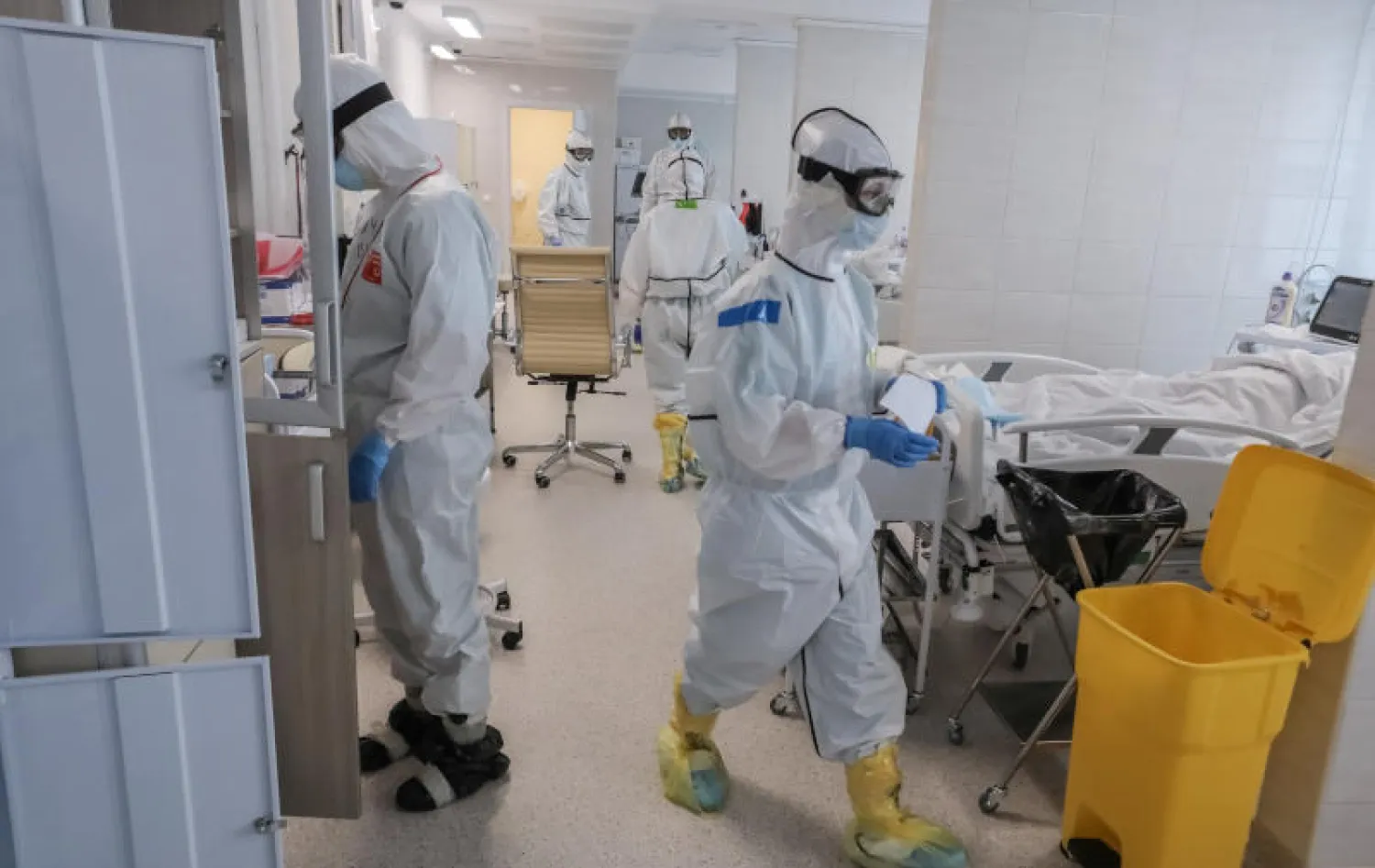 اختصاصيون طبيون يرتدون ملابس واقية يعملون في وحدة عناية مركزة لمرضى كورونا بمستشفى في موسكو (رويترز)