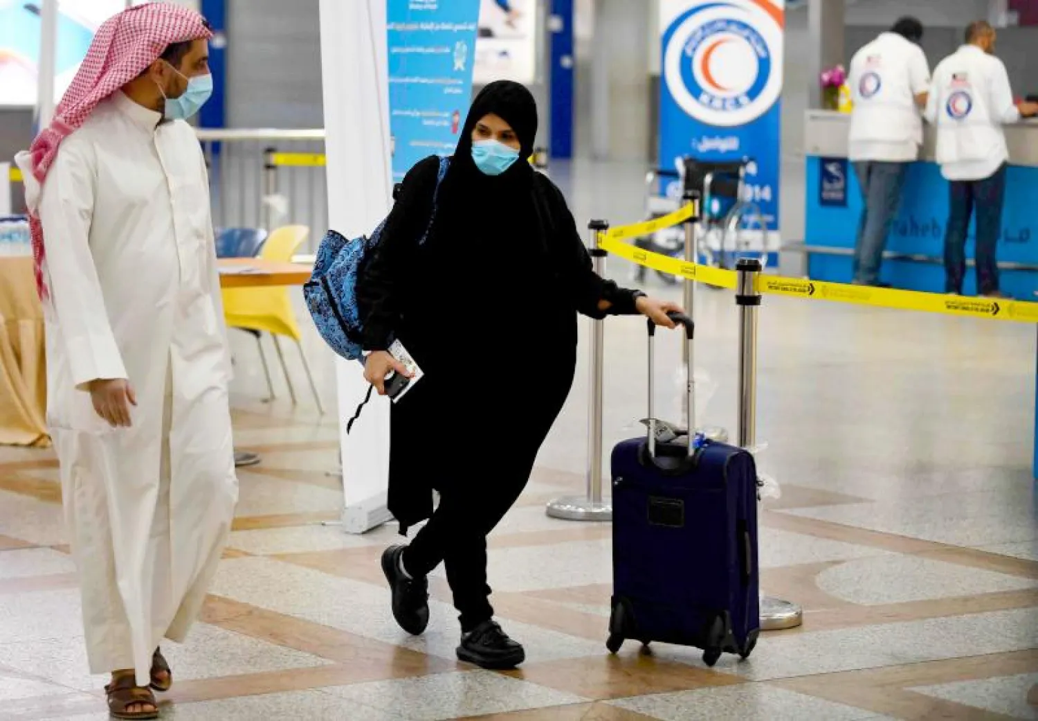 المواطنون الكويتيون العالقون في الخارج لدى وصولهم إلى مطار الكويت الدولي (أ.ف.ب)