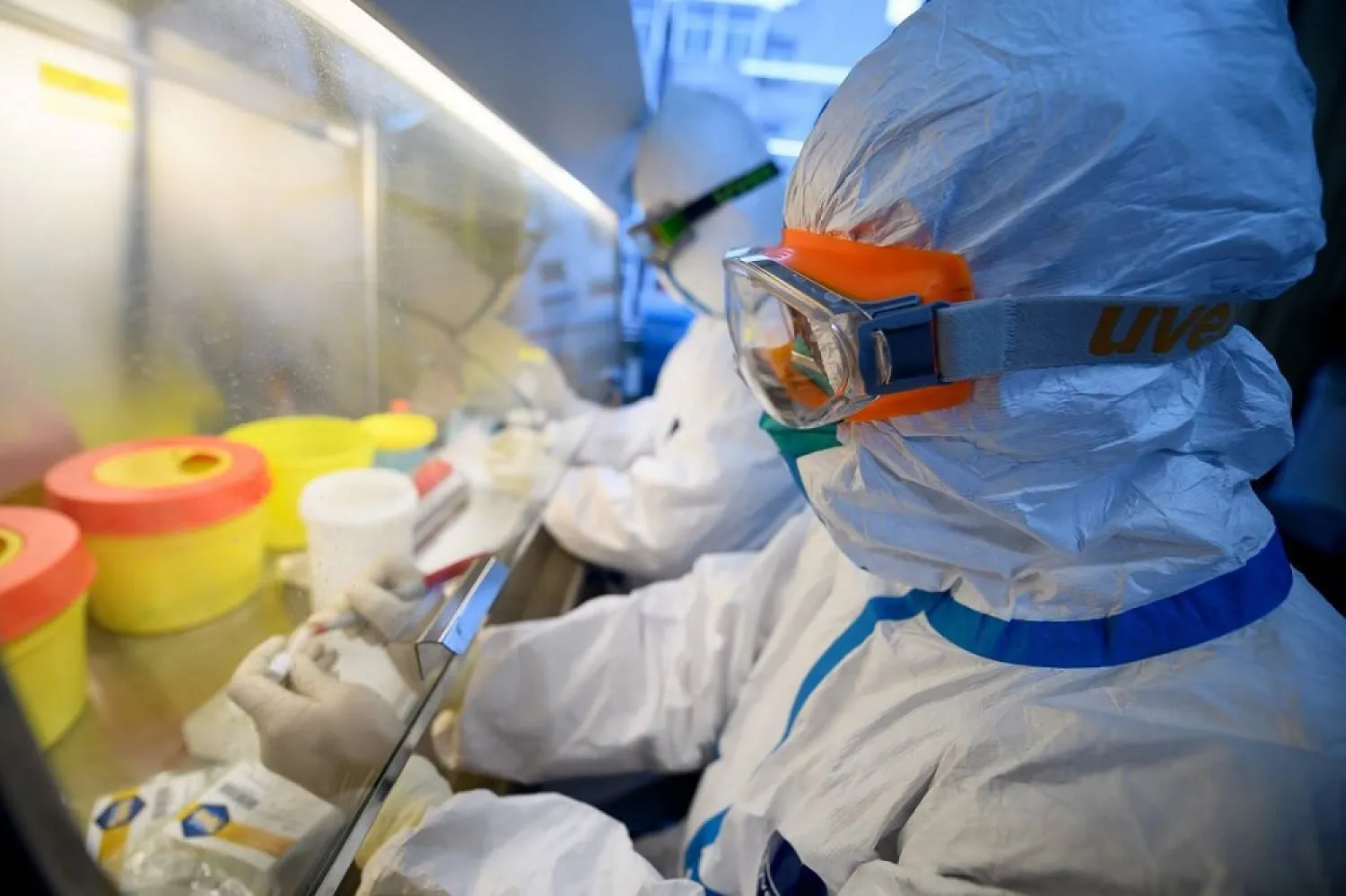 Workers in protective suits test coronavirus specimens inside a laboratory at a center for disease control and prevention in China. (Reuters)