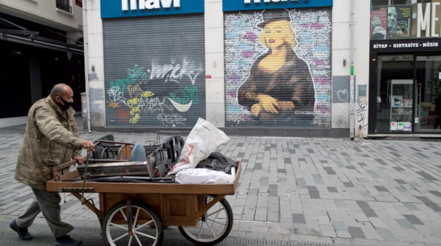 بائع خردة في أحد شوارع إسطنبول المغلقة أمس (إ.ب.أ)