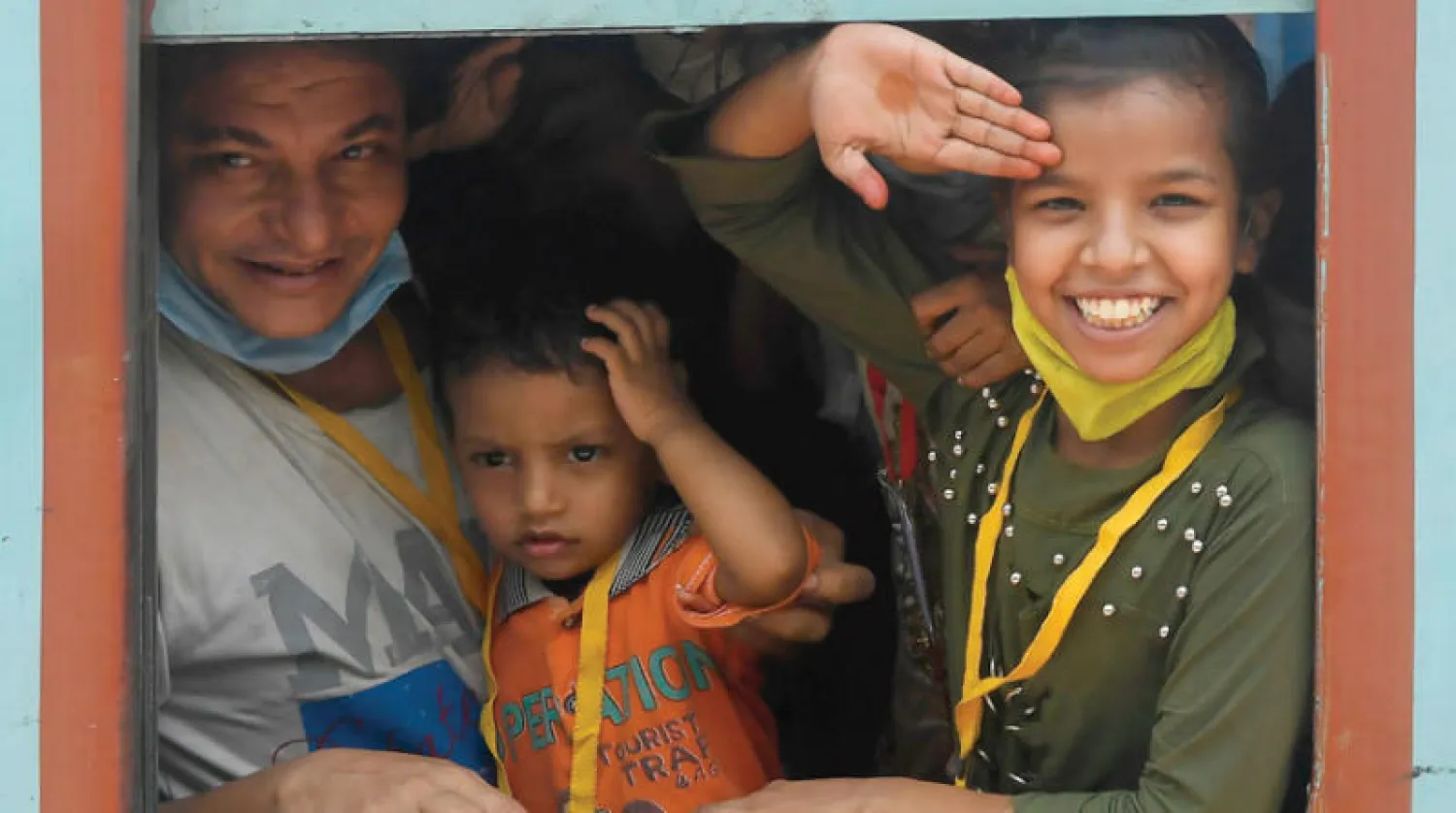 أطفال هنود يلوّحون من نافذة قطار لدى وصولهم إلى محطة في ولاية راجستان بعد إجلائهم برحلة مخصصة لإعادة العمال العالقين نتيجة إجراءات التصدي لجائحة «كورونا» أمس (أ.ف.ب)