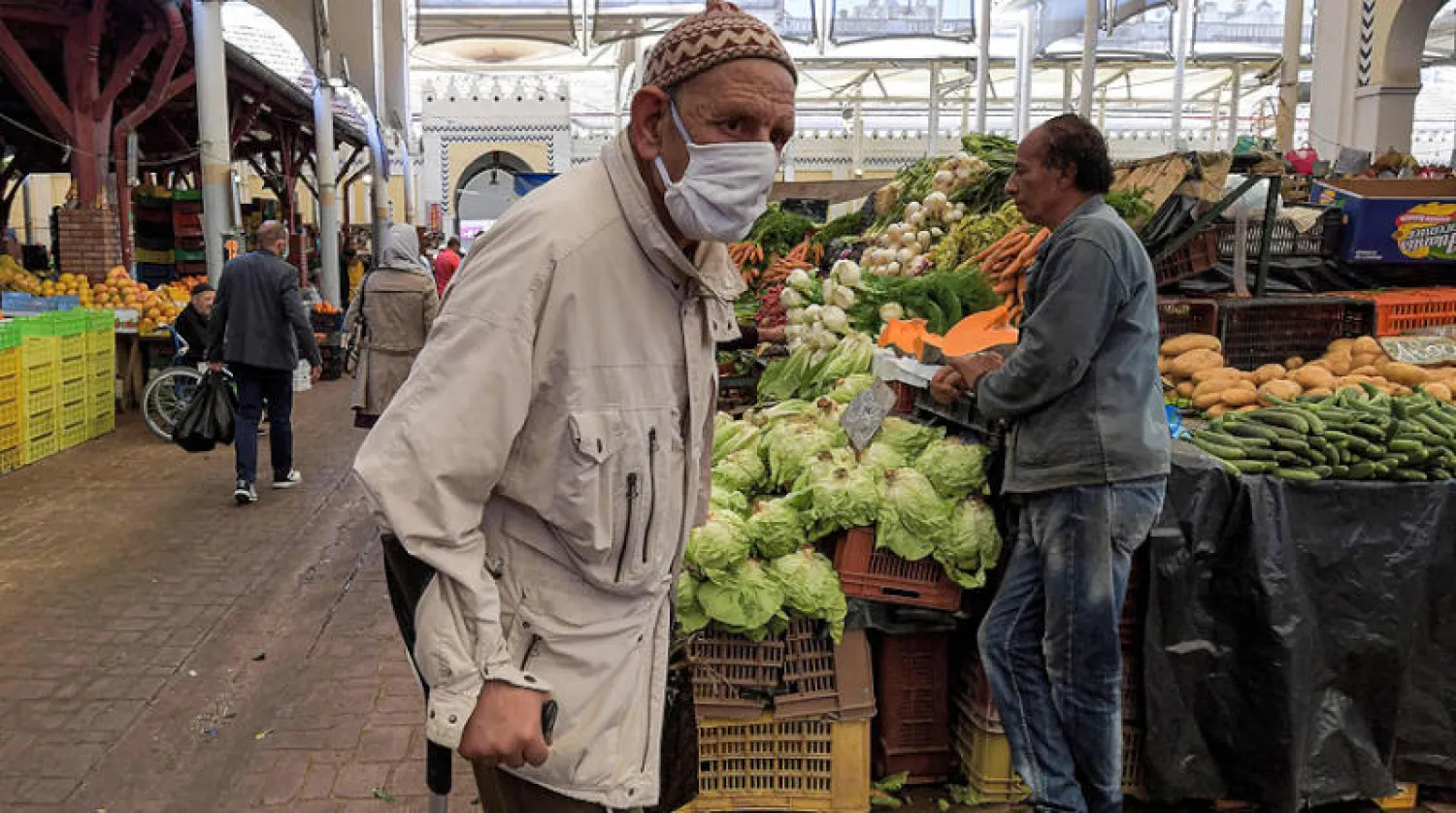 تونسي يشتري مواد غذائية من سوق شعبية وسط العاصمة (أ.ف.ب)