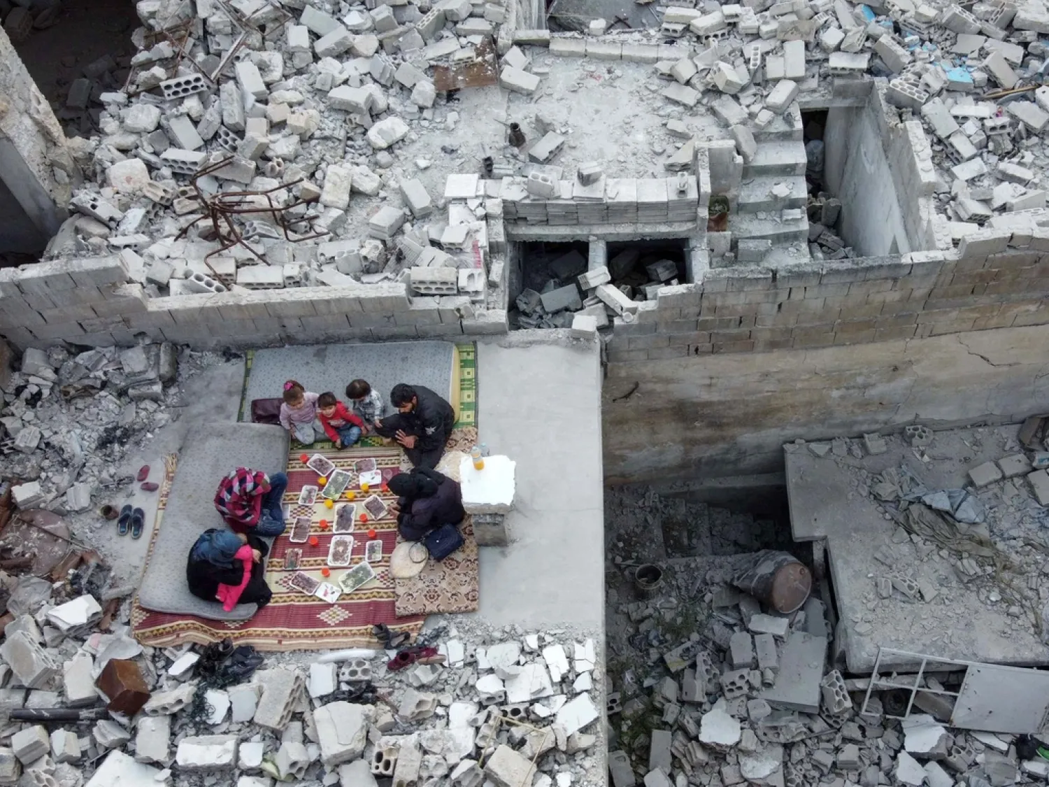 Members of the displaced family of Tareq Abu Ziad, from the town of Ariha in Idlib province, Syria, break their fast together on May 4, 2020, in the midst of their ruined home. (AFP)