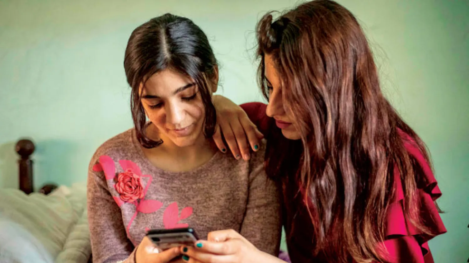 الشابة الإيزيدية ليلى عيدو مع إحدى صديقاتها بقرية في ريف الحسكة شرق سوريا (أ.ف.ب)