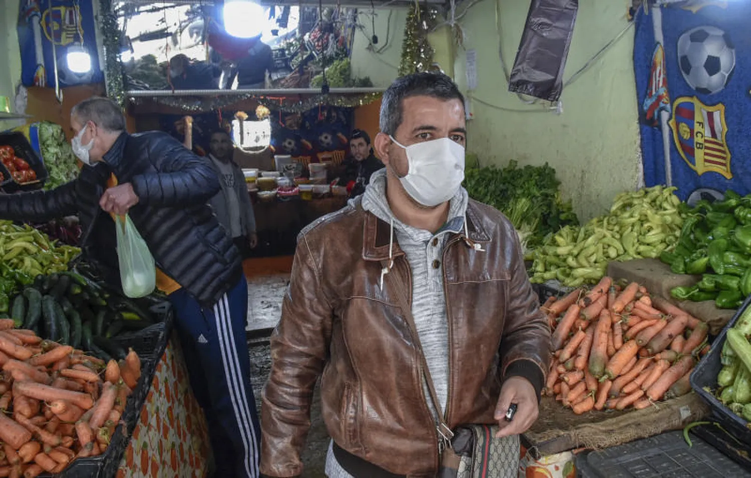 رجل يرتدي كمامة في إحدى الأسواق بجنوب العاصمة الجزائرية (أ.ف.ب)