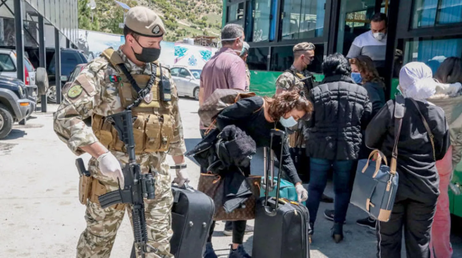 أميركيون كانوا عالقين في الخارج بسبب تداعيات الوباء لدى وصولهم أمس إلى نقطة المصنع على الحدود اللبنانية - السورية، تمهيداً لنقلهم إلى مطار بيروت حيث كانت في انتظارهم طائرة شحن أميركية وصلت أول من أمس  (إ.ب.أ)