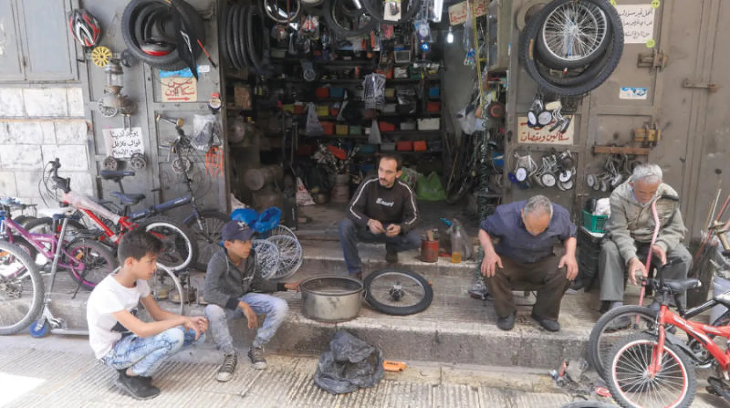 فلسطيني يصلي جالساً أمام ورشته الصغيرة في نابلس أمس (إ.ب.أ)