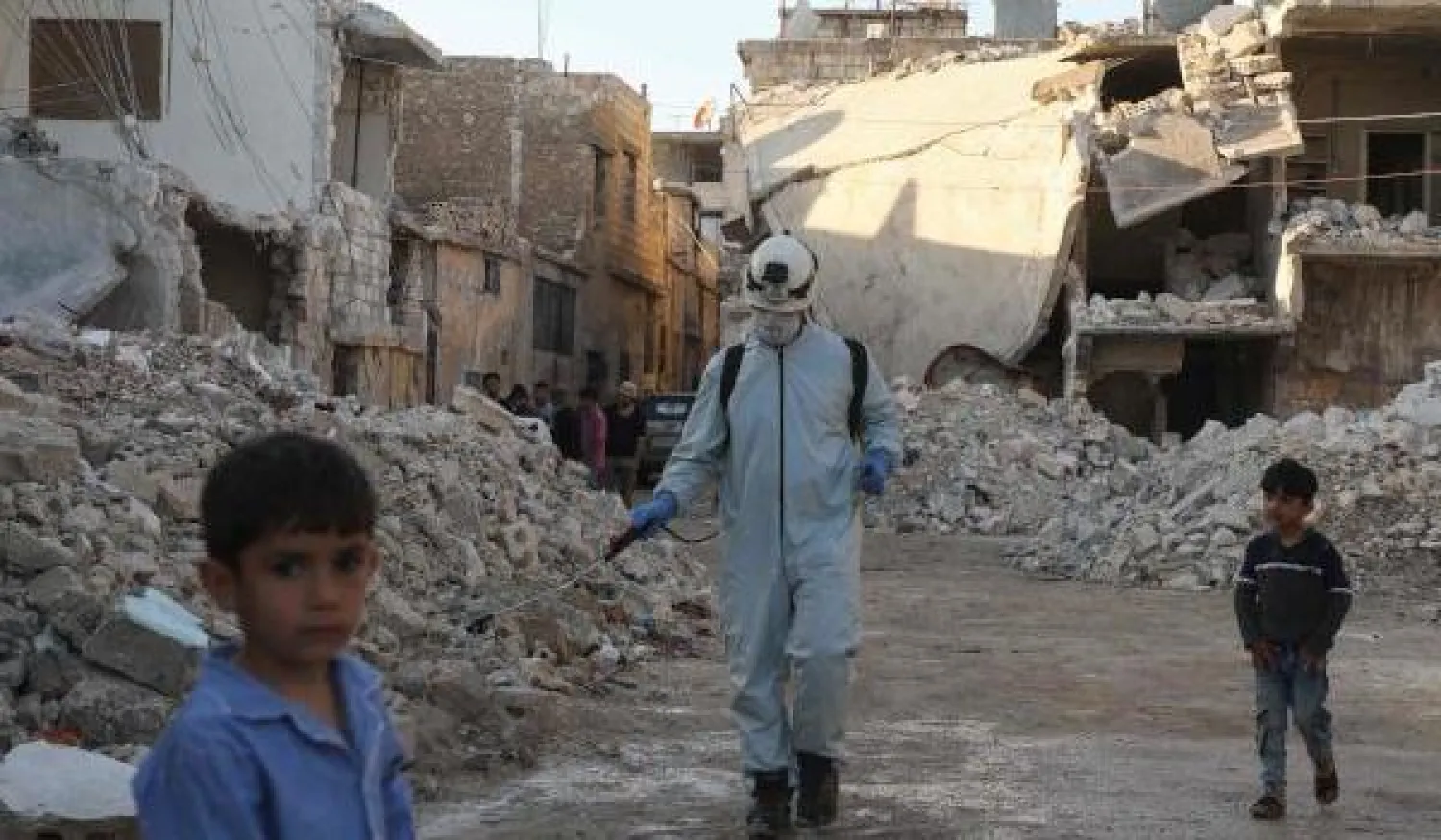 طفل يقف أمام مباني مدمرة في بلدة الأتارب بريف حلب الغربي (أ.ف.ب)