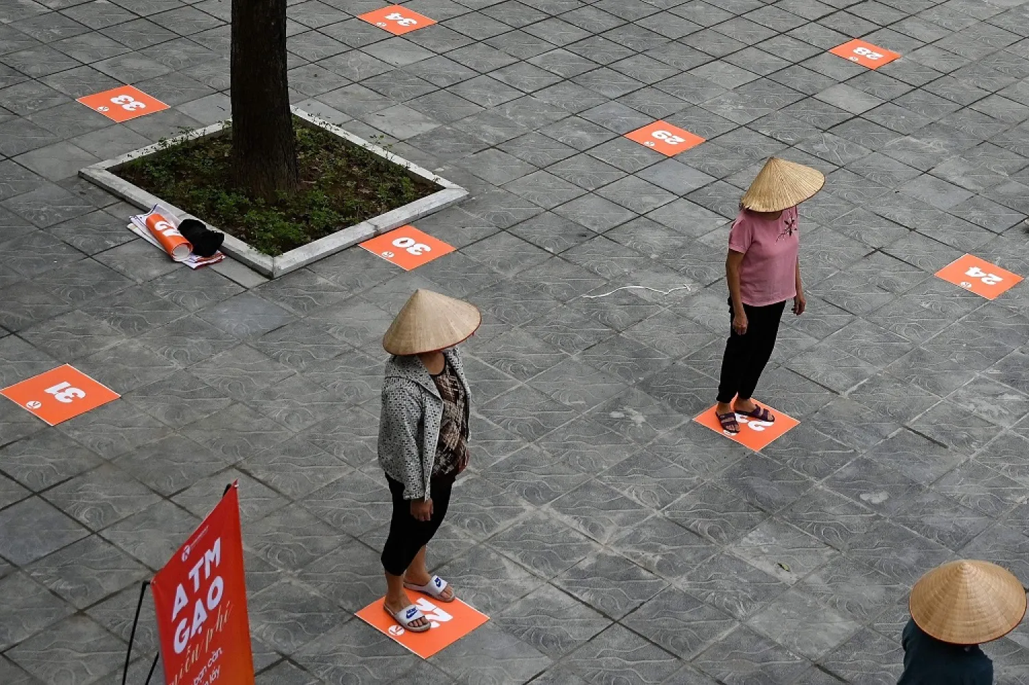 Residents wearing face masks practice social distancing as they wait in a queue for free rice, Hanoi, April 11, 2020. (AFP)