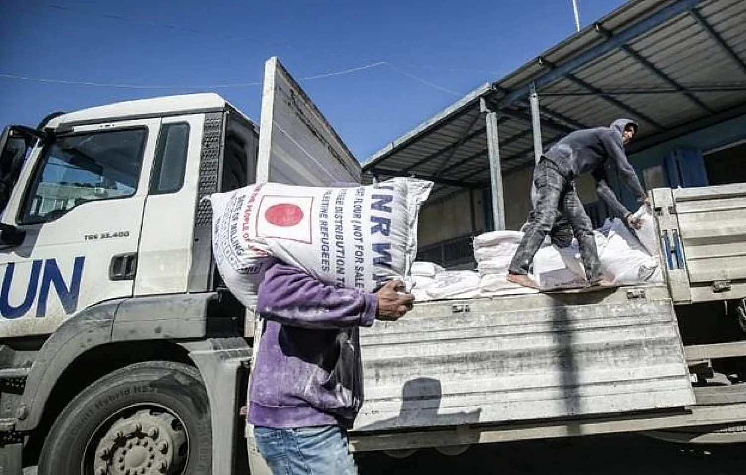 A man transports a sack of flour as people come to receive food aid from a United Nations Relief and Works Agency (UNRWA) centre in the Khan Yunis camp for Palestinian refugees in the Gaza Strip. AFP