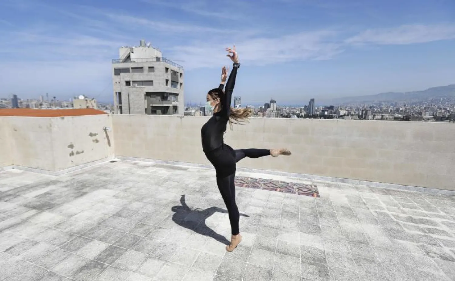 الراقصة التونسية شهرزاد مامي تتدرّب على سطح مبنى (أ.ف.ب)